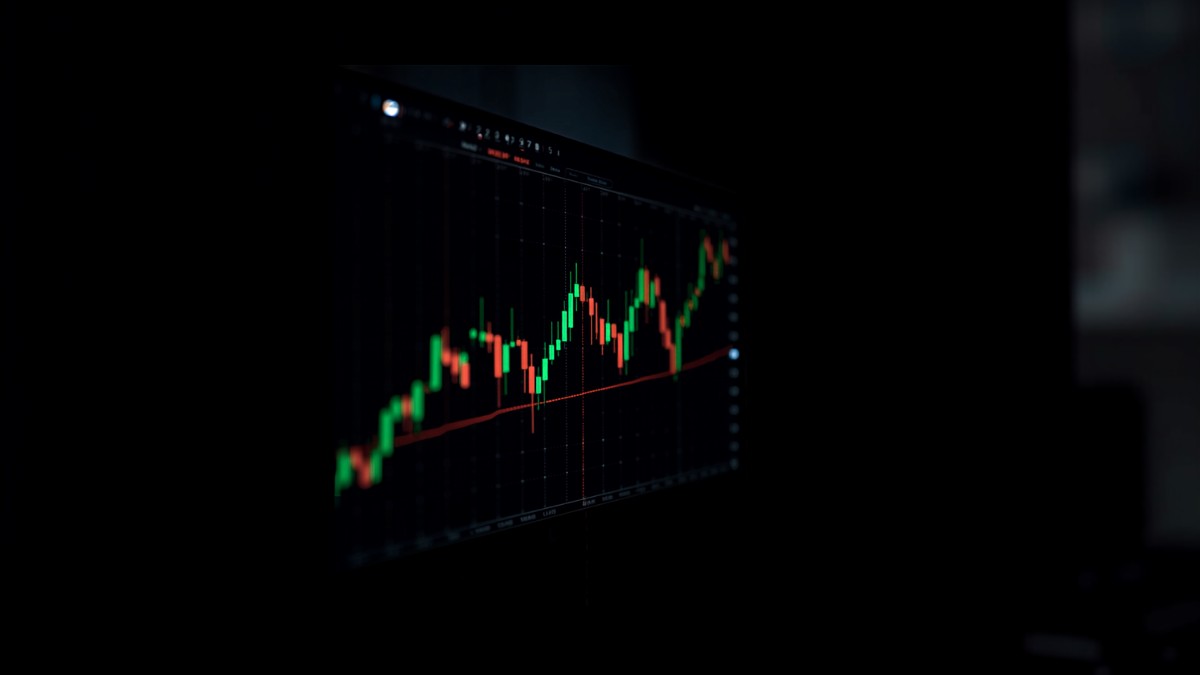Tela de monitor mostrando gráfico de candles de day trade em ambiente escuro de operação