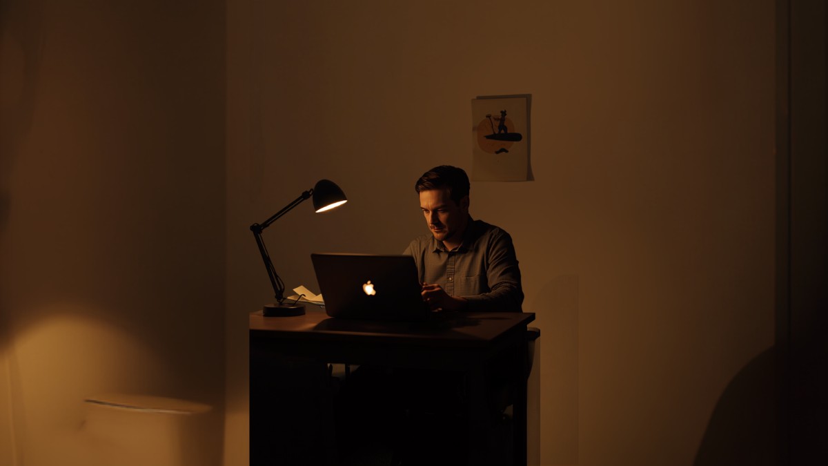 Pessoa trabalhando em notebook a noite construindo uma renda extra